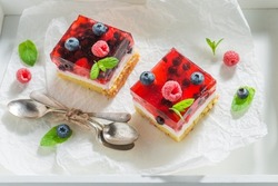 Fruity and homemade cheesecake with fresh raspberries and blueberries as a snack.