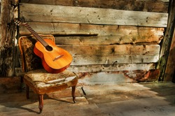 spanish guitar on a old chair with  wooden background horizontal