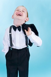 Portrait of a little funny boy in black suit