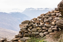Ancient stones of old houses. Stone ruined wall. Panoramic mountain view