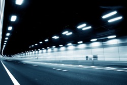 Abstract speed motion in urban highway road tunnel, blurred motion toward the central. Shot from a slow moving car