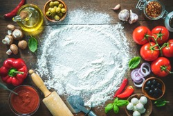 Ingredients and spices for making homemade pizza. Top view with copy space on wooden table 
