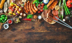 Barbecue menu. Grilled meat and vegetables on rustic wooden table with copy space for text