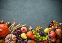 Autumn fruits and pumpkins with fallen leaves on rustic background. Top view