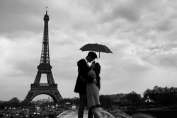 retro view of Paris, couple under umbrella near Eiffel tower, vintage black and white monochrome