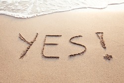 YES concept, positive changes in the life, word written on sand beach