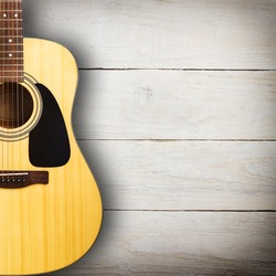 Acoustic guitar against vintage wooden background