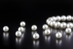 White pearls necklace on black background