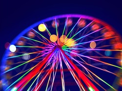 Defocused ferris wheel with colorful lights, Blur abstract background ready for your design