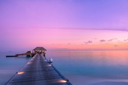 Stunning colorful sunset sky with clouds seaside horizon. Lagoon landscape in Maldives. Luxury traveling destination, exotic summer beach view. Tropical vacation and summer holiday background concept