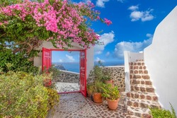 Fantastic travel background, Santorini urban landscape. Red door or gate with stairs and white architecture under blue sky. Idyllic summer vacation holiday concept. Wonderful summer luxury vibes