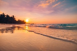 Sunset dramatic sky on sea, tropical desert beach. Dreamy fantasy beach, waves splashing. Warm sunlight peaceful, relaxing paradise island landscape. Exotic nature closeup. Beautiful beachside sunrise