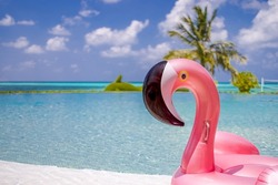 Summer swimming pool with inflatable pink flamingo, luxury resort hotel poolside. Happy blue cloudy sky, tropical paradise island infinity pool sea view. Vacation, holiday fun landscape. Relax leisure