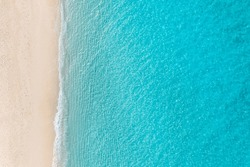 Summer seascape beautiful waves, blue sea water in sunny day. Top view from drone. Relax sea aerial view amazing tropical nature background. Tranquil bright sea waves splashing beach sand sunset light