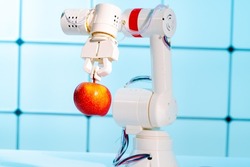 Robot arm with red apple. robot hand is holding a red apple. Modern technology  robotics concept.