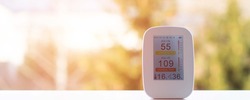 air quality meter on the windowsill shows poor quality at sunrise in the early morning. air quality tester for air quality for measuring humidity, temperature and air purity. poor monitor