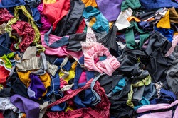 The background of many rag pieces of colorful fabrics which have been left from the sewing and repairing of the clothes by an elderly Thai woman for a long time.