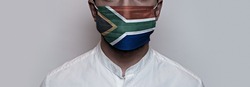 Corona virus pandemic. Concept of Corona virus quarantine, Covid-19. The male face is covered with a protective medical mask, painted in South Africa flag colors