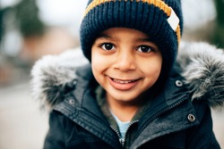 close up portrait of mixed race cute happy smiling child on a cold winter day 