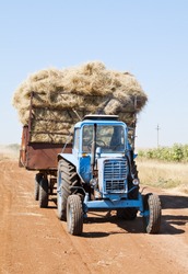 Tractor with hay cart on a field road