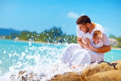 a moment of water splashing on happy father and son