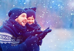 happy father and son having fun under winter snow
