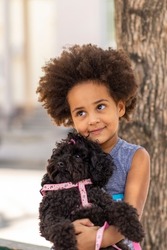 beautiful black girl child hugging poodle dog