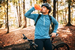 Sport. A cyclist on a bike with a mountain bike in the forest. Making a short break. Drinking water.