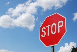 Red Stop Sign with Blue Sky and Clouds Background