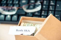 401k ira roth on pieces of colorful paper dollars on table. Pension concept. Retirement plans.