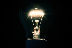 Dazzling filament bulb on background
