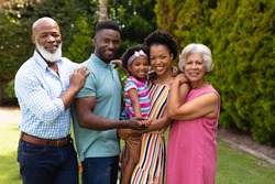 Portrait of smiling three generational african american family standing together at garden. family, love and togetherness concept, unaltered.