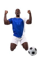 Excited male african american soccer player kneeling while celebrating goal over white background. unaltered, sport, competition and game concept.