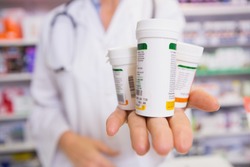 Pharmacist presenting medications on her hand in the pharmacy
