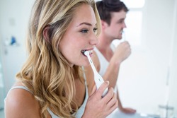 Young couple brushing their teeth at home in the bathroom