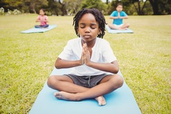 Portrait of child doing yoga with friends in the park