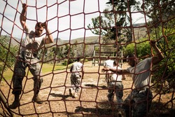 Soldiers performing training exercise on net in bootcamp