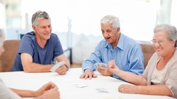 Retired people playing cards together at home
