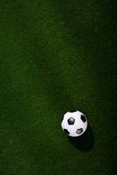 One football soccer ball on a green grass field. Sport background. Top view.