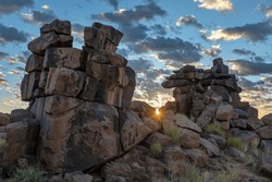 Sun starburst between the rocks at sunrise Giants Playground Namibia