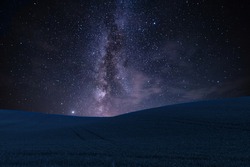 Night landscape with field on hills and Milky way sky