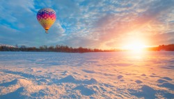 Hot air balloon in the sky in winter at amazing sunset