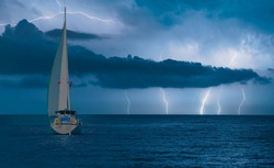 Sailing yacht in a stormy weather with thunder and lightning