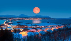 Urban landscape of Tromso in Northern Norway with full moon - Arctic city of Tromso with bridge -Tromso, Norway 