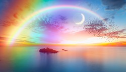 Dusk rainbow concept - Beautiful landscape with multi colored calm sea with double sided rainbow at dusk
