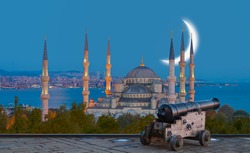 Ramadan Concept - Sultan Ahmet Mosque and Bosphorus with crescent moon, Black a cannon in the foreground at twilight blue hour - Istanbul, Turkey
