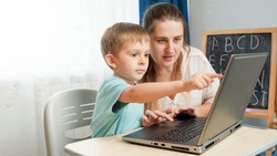 Little boy with young mother studying on laptop. Children using computer and gadget for education and learning