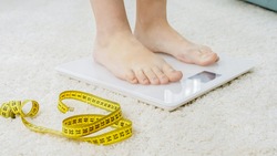 Barefoot woman standing on digital scales. Concept of dieting, loosing weight and healthy lifestyle.