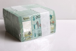 A stack of Lebanese pounds, 100,000 denomination, symbolizing the downfall of the Lebanese currency.