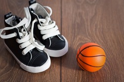 Baby boots on wood floor and a basketball